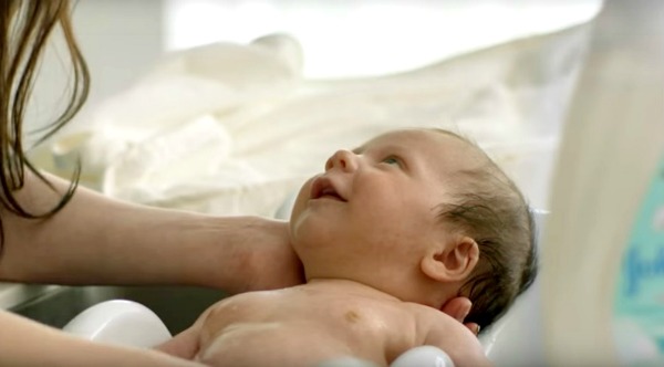 Baby smiling up at mum during bath. JOHNSON’S Choose Gentle