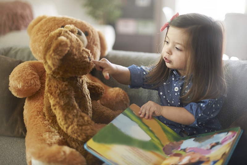 a girl storytelling with her teddy bears