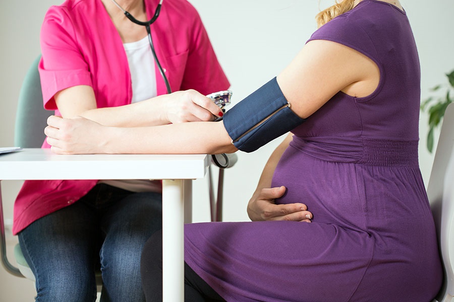 Close-up of doctor measuring pressure of pregnant woman