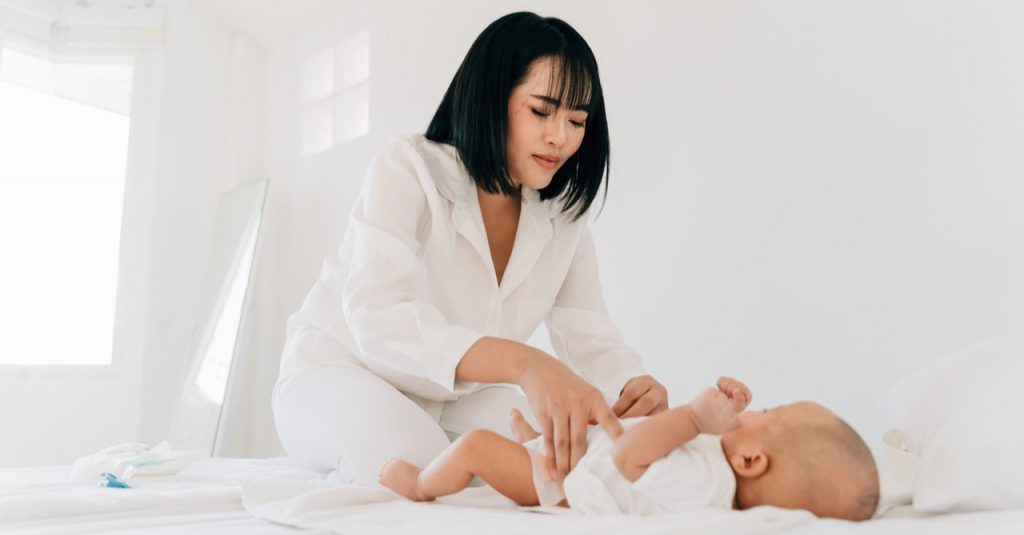 mother changing baby's diaper to mamypoko