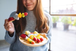 girl eating fruit skewer