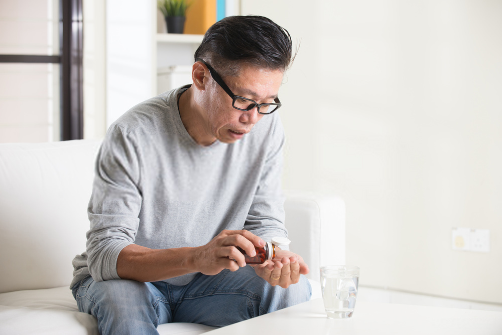 older man taking vitamin