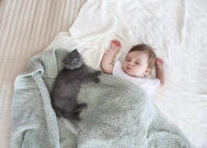 baby sleep with a cat, one of his pets