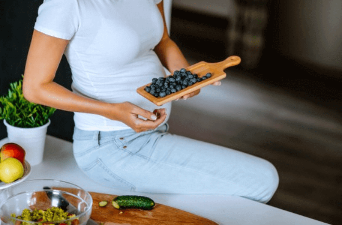 pregnant mother holding blueberries