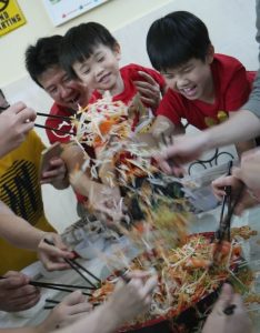 family eating yee sang 