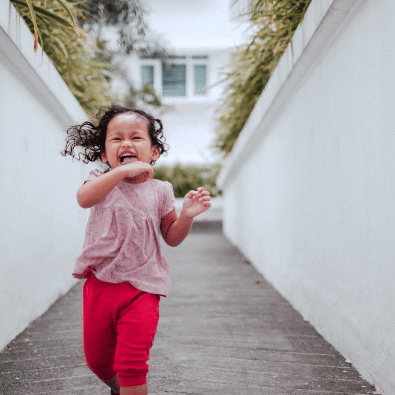 A girl is running happily in the park.