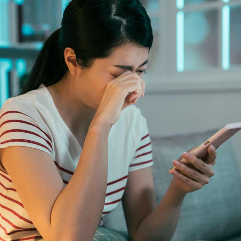 A lady feeling sad looking at her phone