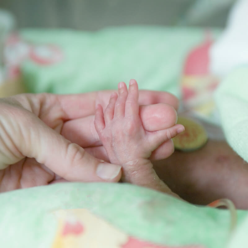 A mum holding babys hand