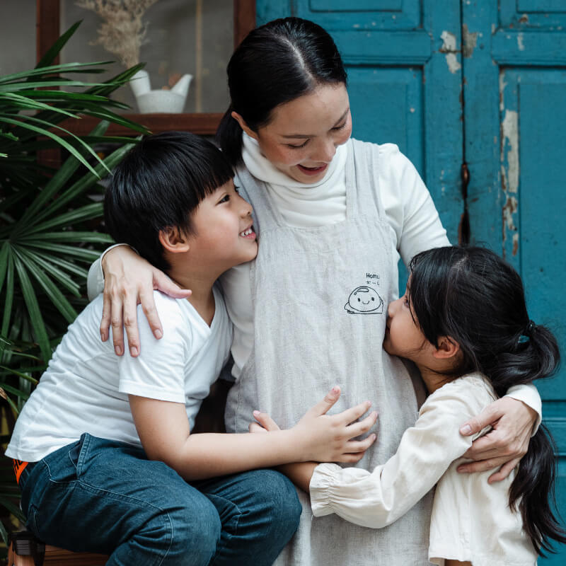 A mum hugging her two kids