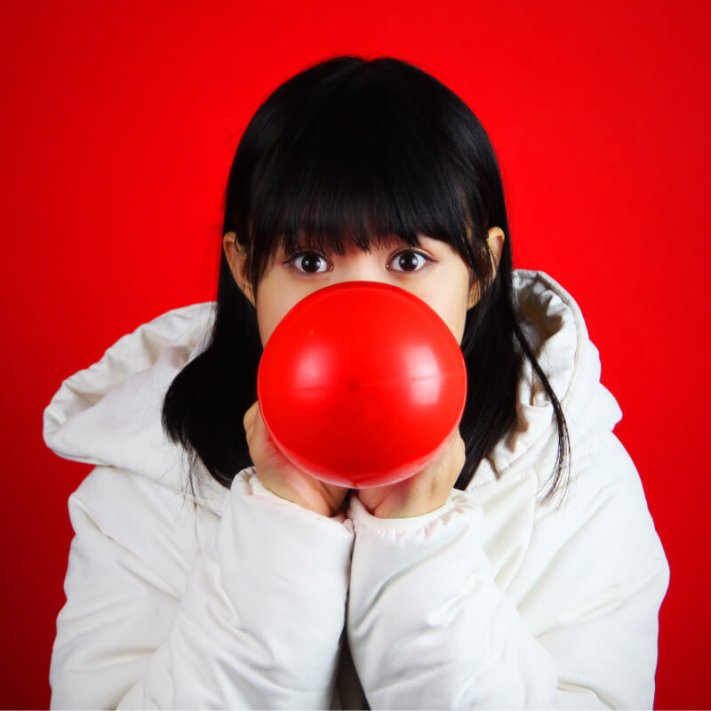 A girl blowing a balloon