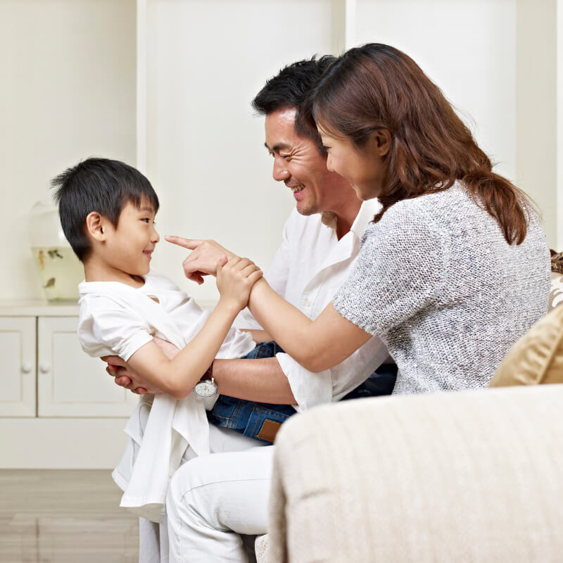 A boy with his parents on the couch