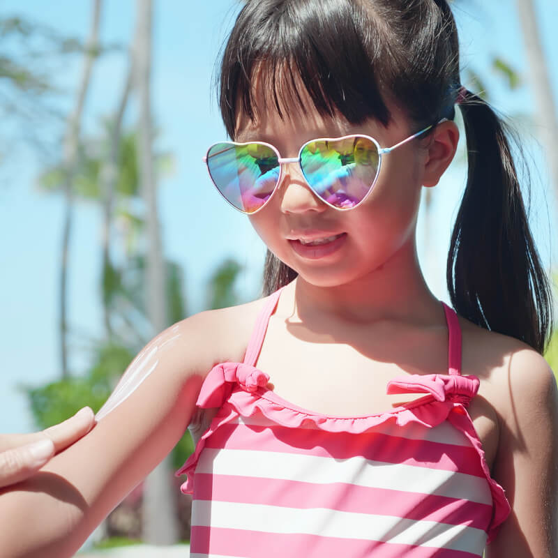 A girl applying sunscreen