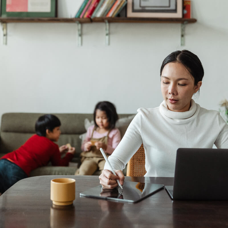 A mum doing work while kids on school holidays