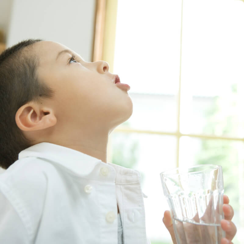 A boy gargling because of Tonsillitis