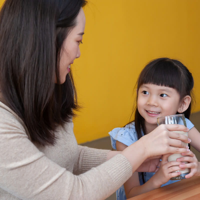 a mum and kid holding a cup