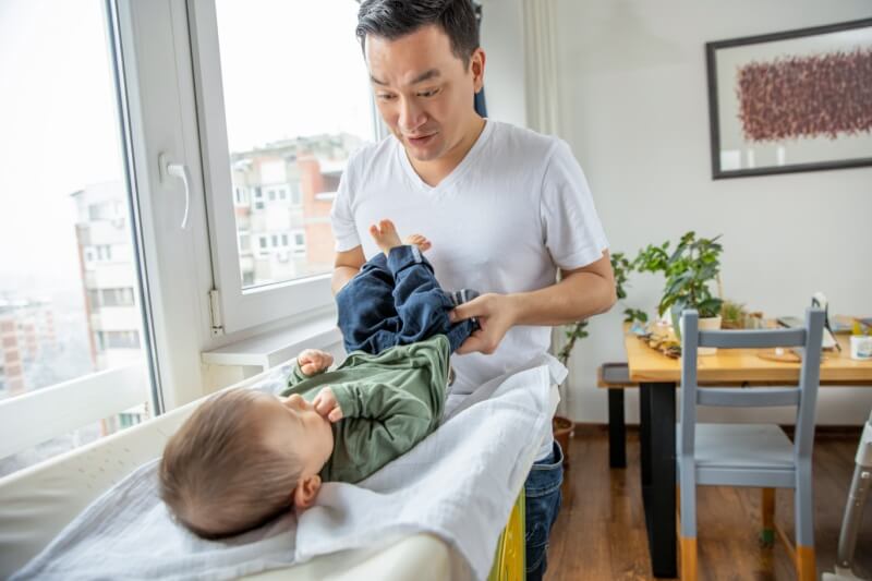 father changing diapers on son