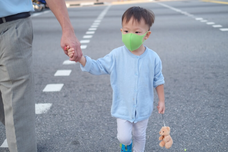 father and son crossing the road