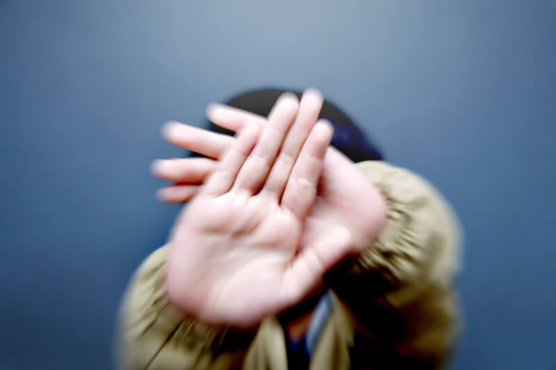 young boy closing his face