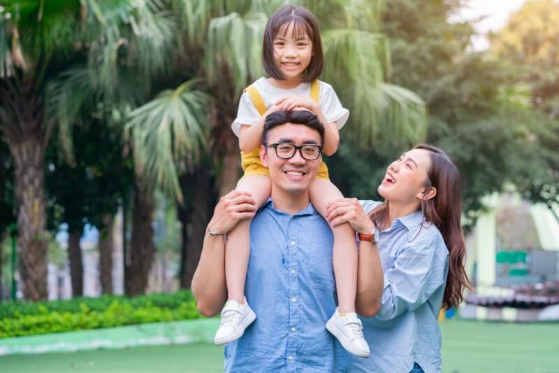 father carrying daughter on shoulder