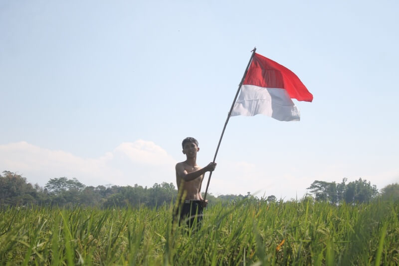 boys celebrating Indonesian independence by waving the flag as a form of love for their homeland,