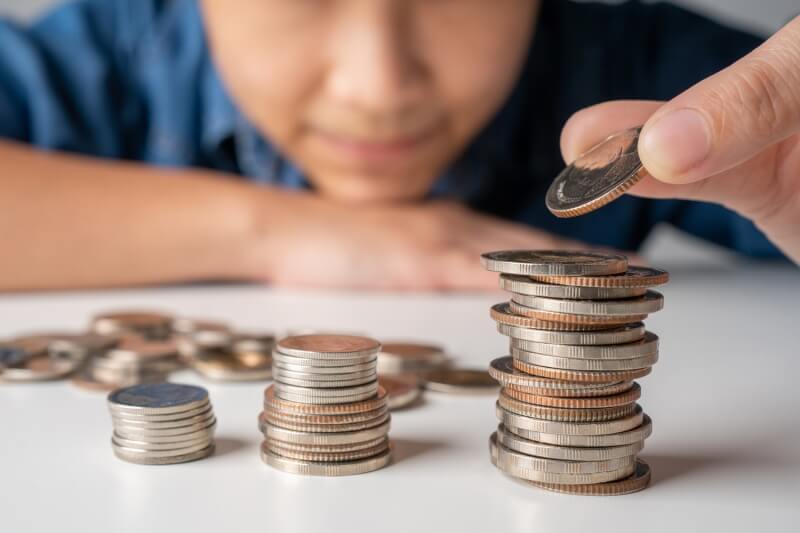 boy looking at stacked up coins