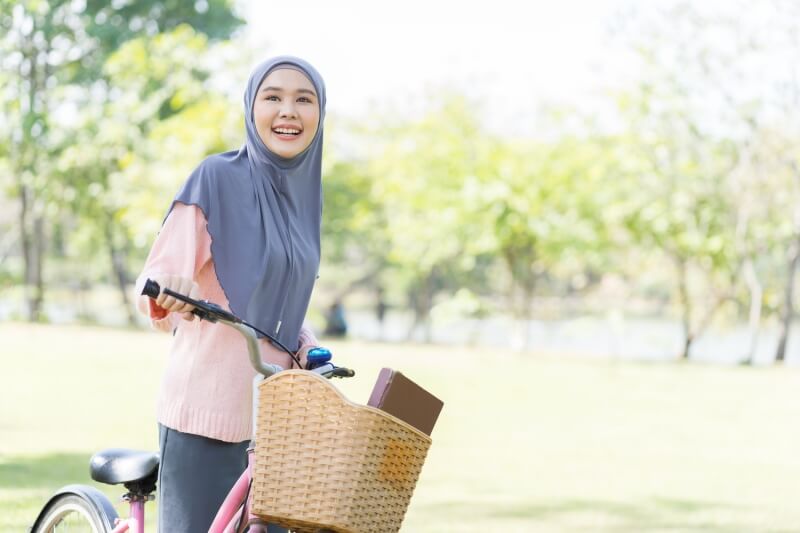 woman wearing headscarf while riding bicycle 